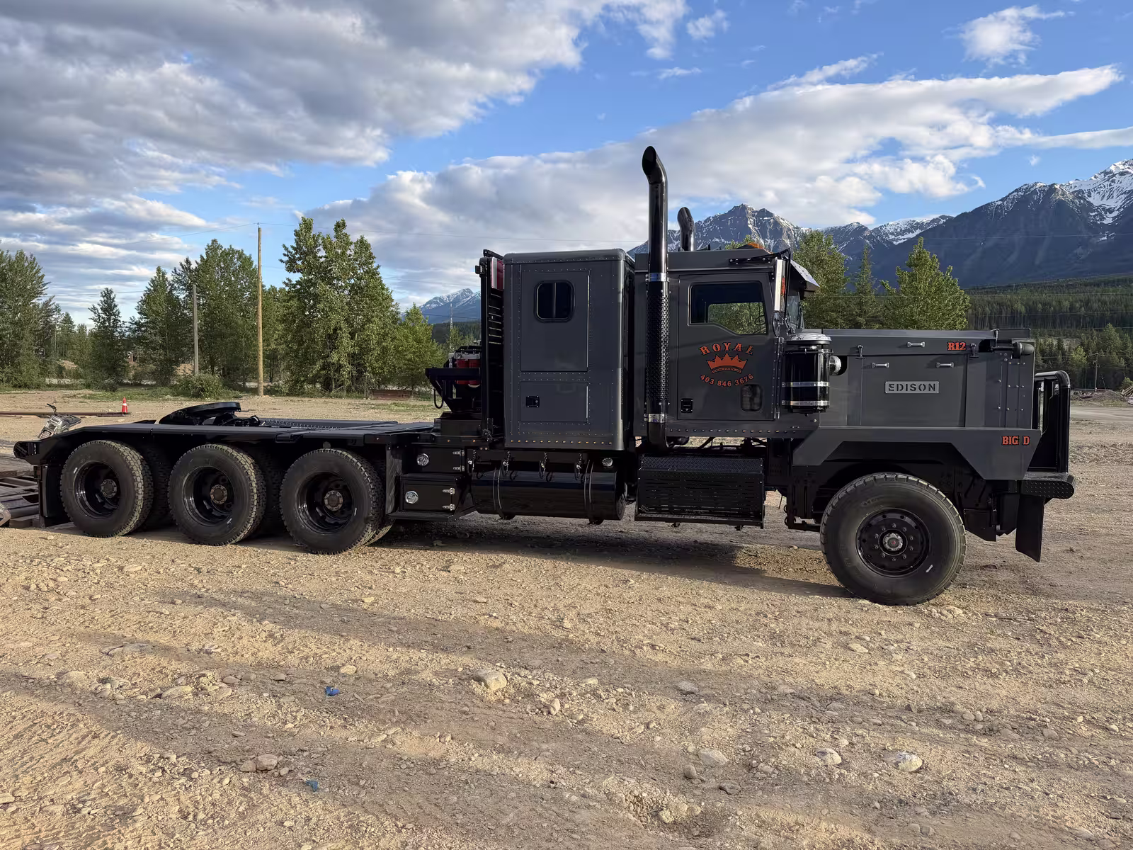 Side profile of the Royal Oilfield R12 winch tractor with the Rocky Mountains behind